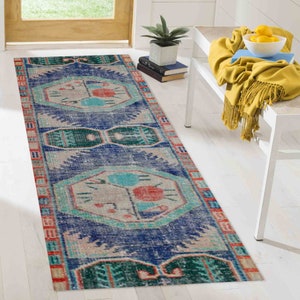 May include: A blue and red patterned runner rug with a geometric design. The rug has a distressed look and is made of a soft, woven material.