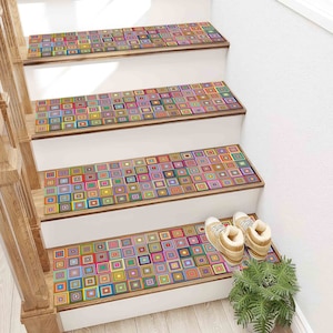 May include: A set of four colourful stair treads featuring a geometric pattern of squares in various colours. The treads are made from a durable material and are easy to install. They are ideal for adding a touch of style and personality to any staircase.