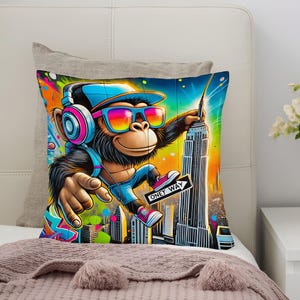 Könnte beinhalten: Ein farbenfrohes Zierkissen mit einem Cartoon-Affen, der eine Sonnenbrille, eine blaue Kappe und Kopfhörer trägt. Der Affe hält einen Stock und zeigt auf das Empire State Building. Das Kissen hat den Text "Oney Way" auf einem Schild.