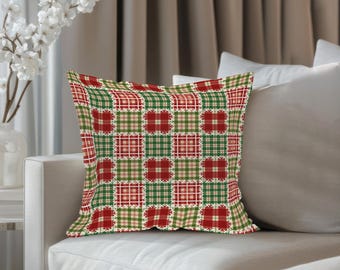 Könnte beinhalten: Ein dekoratives quadratisches Kissen mit Patchwork-Design. Das Kissen hat ein Muster aus roten, grünen und cremefarbenen Quadraten, die in einem Raster angeordnet sind. Die Quadrate haben ein Karomuster, und das Kissen liegt auf einem weißen Sofa.