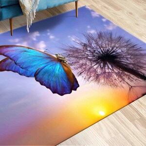 May include: A blue butterfly with brown veins sits on a purple dandelion with a sunset background.