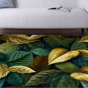 Pode incluir: Um tapete azul marinho com um padrão de grandes folhas verdes e douradas. As folhas são estilizadas e têm uma textura realista.