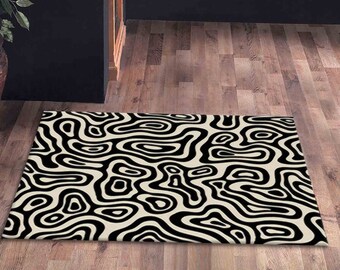 Pode incluir: Tapete abstrato preto e branco com um padrão de redemoinho. O tapete tem um fundo creme com linhas pretas que criam um design ondulado e orgânico.