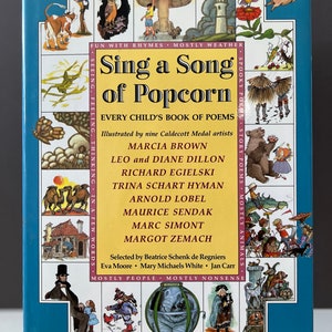 Puede incluir: Una cubierta de libro azul con ilustraciones de animales y personas. El título es "Sing a Song of Popcorn" y el subtítulo es "Every Child's Book of Poems". El libro está ilustrado por nueve artistas ganadores de la Medalla Caldecott.