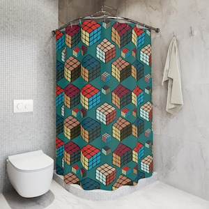 May include: A teal shower curtain featuring a repeating pattern of colorful Rubik's Cubes. The cubes are in various sizes and orientations, with red, blue, yellow, and brown colors. The curtain is hanging in a bathroom setting.