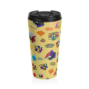 Könnte beinhalten: Ein Reisebecher mit schwarzem Deckel und gelbem Korpus. Der Korpus ist mit bunten Rubik's Cube-Grafiken und dem Text "DREAM PRACTICE REPEAT" versehen. Der Becher ist so konzipiert, dass er Getränke heiß oder kalt hält.