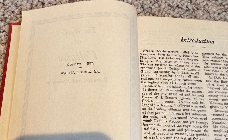May include: A page from a vintage book with the title "Voltaire" and a copyright date of 1927. The page contains an introduction to the life and works of the French writer Voltaire, known for his wit and satire.