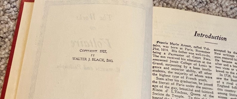 May include: A close-up of a book's copyright page, showing the text "COPYRIGHT. 1927, TY WALTER J. BLACK, INC." and an introduction to the book, which begins with "Francis Marie Aronet, called Voltaire, was born at Paris, November 21st, 1604. His father was well-to-do, being a Paymaster of Court Fers."