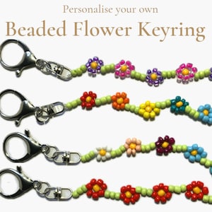 May include: A selection of beaded flower keyrings. Each keyring displays a chain of colourful beaded flowers, such as red, orange, yellow, pink, purple, and blue, linked by a green beaded stem. The keyrings have silver clasps.