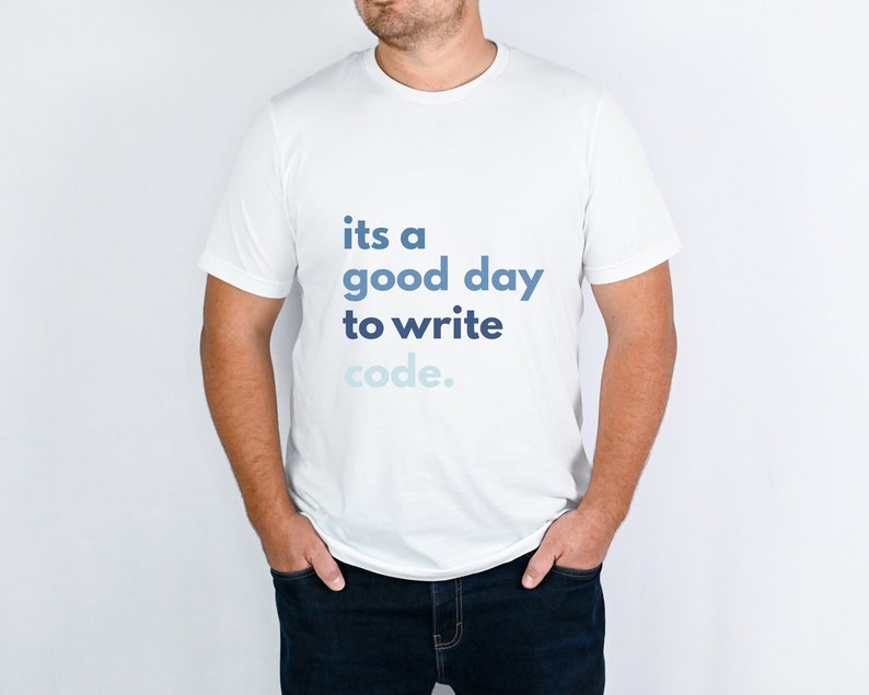 May include: White crew neck t-shirt featuring the text "its a good day to write code" in blue hues. The shirt is made of a soft material.