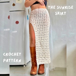 Op de afbeelding: Een witte gehaakte rok met een hoge split en een geometrisch patroon. De rok heet "The Sunrise Skirt" en is een haakpatroon.