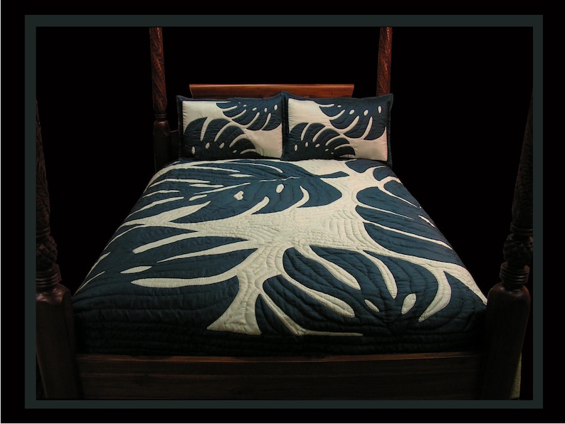 May include: A teal blue quilted bedspread with a white monstera leaf design. The bedspread is on a wooden bed frame with a headboard and footboard.