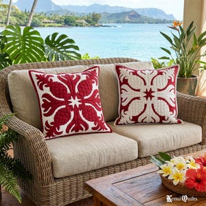 May include: Two square throw pillows featuring a red and white quilted pattern with a central star motif. The pillows are placed on a beige wicker sofa. The text Kenui Quilts is visible in the bottom right corner of the image.