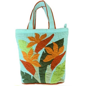 May include: A light blue quilted tote bag with orange and green floral applique. The bag has matching light blue handles with orange trim and a zipper closure. The bag is approximately 12 inches wide and 14 inches tall.