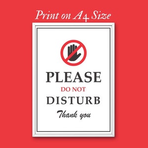 Pode incluir: Um sinal branco com um círculo vermelho e uma mão preta com uma linha diagonal que a atravessa. O texto no sinal diz "PLEASE DO NOT DISTURB Thank you".