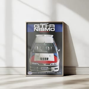 May include: A framed poster of a Nissan Pulsar GTI-R NISMO race car. The car is white, red, and blue, with the NISMO logo. The poster is against a white wall with natural light. The poster is in a wooden frame.