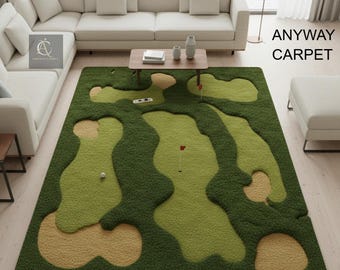 May include: A green and tan golf course-themed area rug. The rug features a detailed design of a golf course with fairways, sand traps, and putting greens. A golf ball and red flags are visible on the rug. The text "ANYWAY CARPET" is on the right side.
