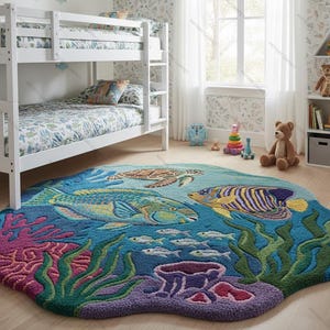 May include: A colorful, ocean-themed rug featuring a vibrant underwater scene. The rug showcases a variety of marine life, including fish, a sea turtle, and coral. The rug's design incorporates shades of blue, green, purple, and pink.