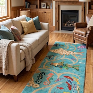 Puede incluir: Una alfombra rectangular con un fondo turquesa vibrante y un patrón detallado de diversas especies marinas, incluyendo peces, caballitos de mar y una raya, conectados por motivos beige en forma de enredadera. La alfombra tiene flecos y texto.