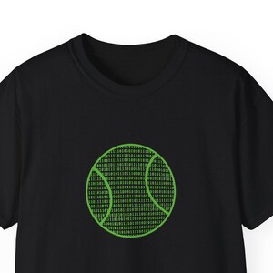 Peut inclure: T-shirt noir avec un motif de balle de tennis verte. La balle de tennis est constituée d'un motif de code binaire. Le t-shirt a des manches courtes et un col rond.