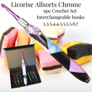 May include: A 9-piece interchangeable crochet hook set titled Licorise Allsorts Chrome. The set includes hooks in sizes 3, 3.5, 4, 4.5, 5, 5.5, 6, and 7. The handle features a black, white, blue, and purple resin design with a metallic tip.
