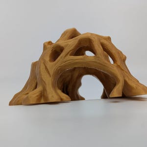 May include: A tan-colored, decorative tree stump with a hollowed-out center, featuring multiple openings and a textured surface. The design resembles a natural tree trunk with a tunnel-like opening, suitable for home decor or as a pet habitat.