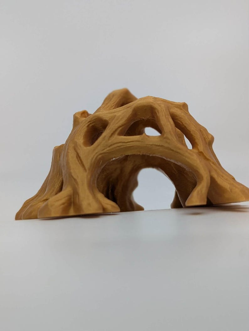 May include: A tan-colored, decorative tree stump with a hollowed-out center, featuring multiple openings and a textured surface. The design resembles a natural tree trunk with a tunnel-like opening, suitable for home decor or as a pet habitat.