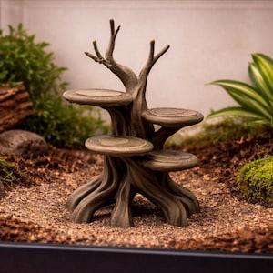 May include: A brown, tree-shaped terrarium decoration with four circular platforms and detailed bark texture. The artificial tree has multiple branches at the top and is designed to provide climbing and resting spots for small pets. The decoration is set in a naturalistic environment.