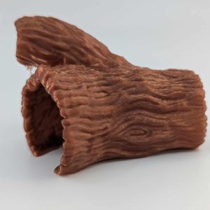 Op de afbeelding: Een bruin, 3D-geprint, hol object in de vorm van een boomstam met een textuur die lijkt op boomschors.