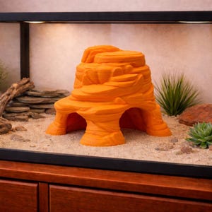 May include: Orange reptile habitat hideout, designed as a layered rock formation. The hideout has multiple arches and a textured surface, creating a naturalistic appearance. It is designed to provide shelter and a comfortable environment for reptiles.