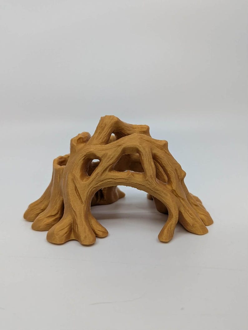 May include: A detailed, tan-colored miniature tree stump with an archway. The sculpture features intricate details of bark and branches, creating a naturalistic appearance. Ideal for miniature landscapes or dioramas.
