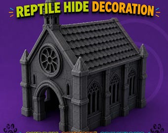 Puede incluir: Un escondite para reptiles en forma de catedral gris oscuro con techo de tejas, un rosetón y puertas arqueadas. El texto CATHEDRAL REPTILE HIDE DECORATION y CUDDLY CRITTER CREATIONS junto con la dirección web aparecen sobre el fondo morado.