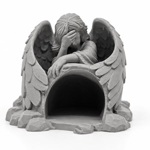 May include: A gray, monochromatic sculpture of a winged figure with long hair, resting its head on one hand while leaning over a hollow, arched stone-like structure. The figure features detailed feathers on its wings and sits on a rocky base.