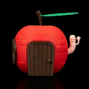 May include: A red apple-shaped house with a brown door and a green leaf on top. A pink worm with a friendly face is sticking out of the side of the house.