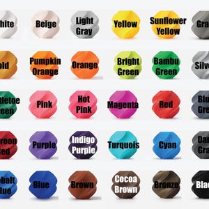 May include: A collection of 28 colorful, textured, spherical objects, each labeled with a different color name. Colors include white, beige, gray, yellow, orange, green, pink, red, blue, and brown.