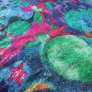 May include: A blue, green, and pink sequined fabric with a star and rainbow design.