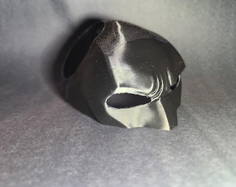 May include: A black plastic Batman mask with a white outline around the eyes.