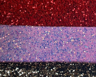 Op de afbeelding: Vier stofstalen met pailletten in zwart, rood, paars en goud.