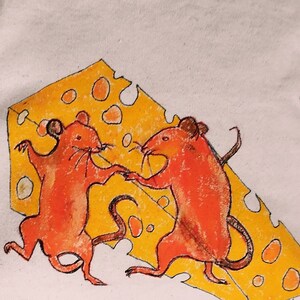 Könnte beinhalten: Weißes Sweatshirt mit orangefarbenem Ausschnitt. Es zeigt eine skurrile Illustration von zwei orangefarbenen Mäusen, die vor einem gelben Käse tanzen. Die Kunst hat einen handgezeichneten Stil.