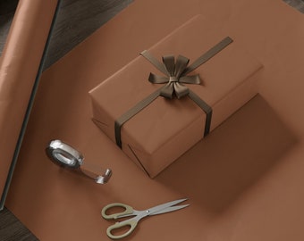 May include: A gift-wrapping scene featuring a brown wrapped present with a ribbon, a roll of brown wrapping paper, scissors, and tape on a wooden table. The scene is set on a wooden table with a neutral background.