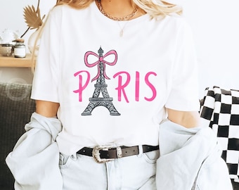 May include: White t-shirt with a pink bow and the Eiffel Tower with the word "PARIS" in pink lettering.