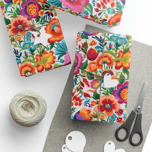 May include: Several gift-wrapped boxes featuring a colourful floral design in shades of orange, pink, and blue. The packages are tied with twine and white tags. A ball of twine, scissors, and blank tags are also present, suggesting a crafting theme.