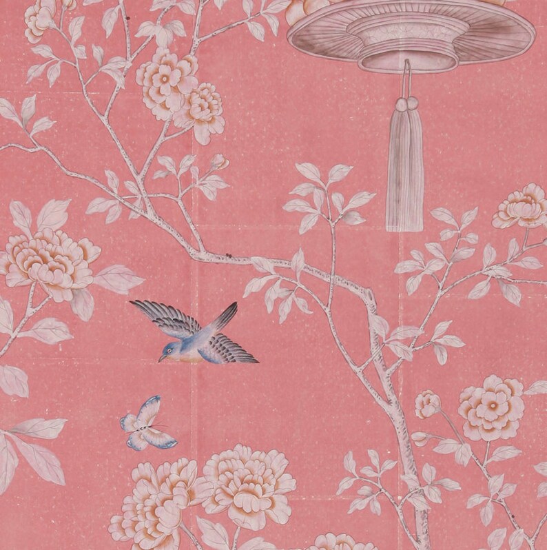 May include: A pink background with a white floral pattern and a blue bird flying. The flowers are in bloom and the bird is in flight. The background is a light pink color.
