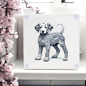 Op de afbeelding: Een zwart-witte Dalmatiër puppy met ingewikkelde bloemmotieven op zijn lichaam. De puppy staat op een witte achtergrond.