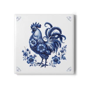 May include: Square ceramic tile featuring a blue and white rooster design. The rooster is adorned with floral patterns and surrounded by blue flowers and foliage. Decorative flourishes are in each corner.