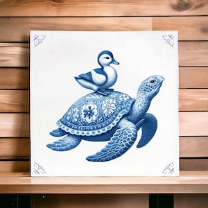 Könnte beinhalten: Eine blaue und weiße Keramik-Schildkröte mit einer blauen und weißen Ente auf dem Rücken. Die Schildkröte und die Ente sind im traditionellen Delftware-Stil bemalt.