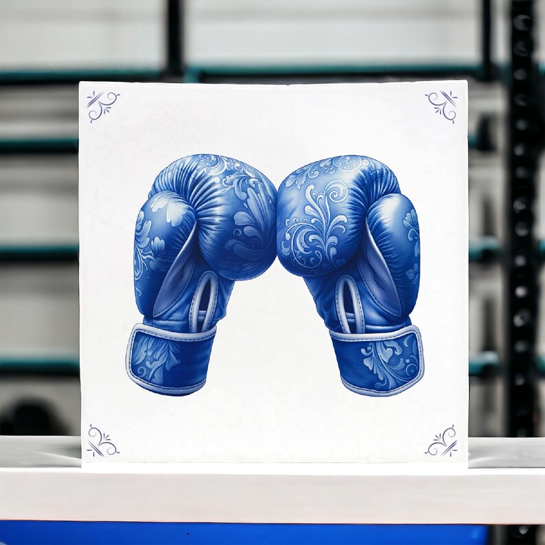 K&ouml;nnte beinhalten: Ein Paar blaue Boxhandschuhe mit einem wei&szlig;en und blauen Blumenmuster. Die Handschuhe sind einander zugewandt, die Handfl&auml;chen nach oben.