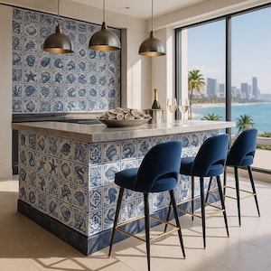 Könnte beinhalten: Ein moderner Barbereich mit gefliestem Rückwand und Arbeitsplatte. Die Fliesen zeigen blau-weiße Muschelmuster. Drei marineblaue Barhocker mit schwarzen Beinen und goldenen Akzenten stehen vor der Bar. Überkopf hängen drei Pendelleuchten.