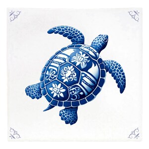 Op de afbeelding: Een blauwe en witte keramische tegel met een gedetailleerde illustratie van een zeeschildpad. De schild van de schildpad is versierd met ingewikkelde bloem- en geometrische patronen.