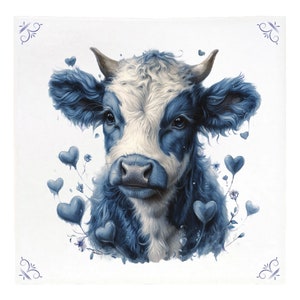 May include: A square, white throw blanket featuring a watercolor illustration of a cow's face. The cow has blue and white fur, with heart-shaped accents and floral details. Decorative blue corner designs complete the design.